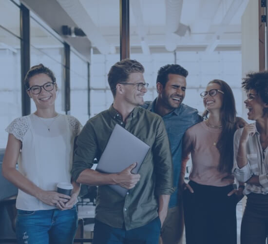 Bild, welches Mitarbeiter zeigt, die sich anlächeln.